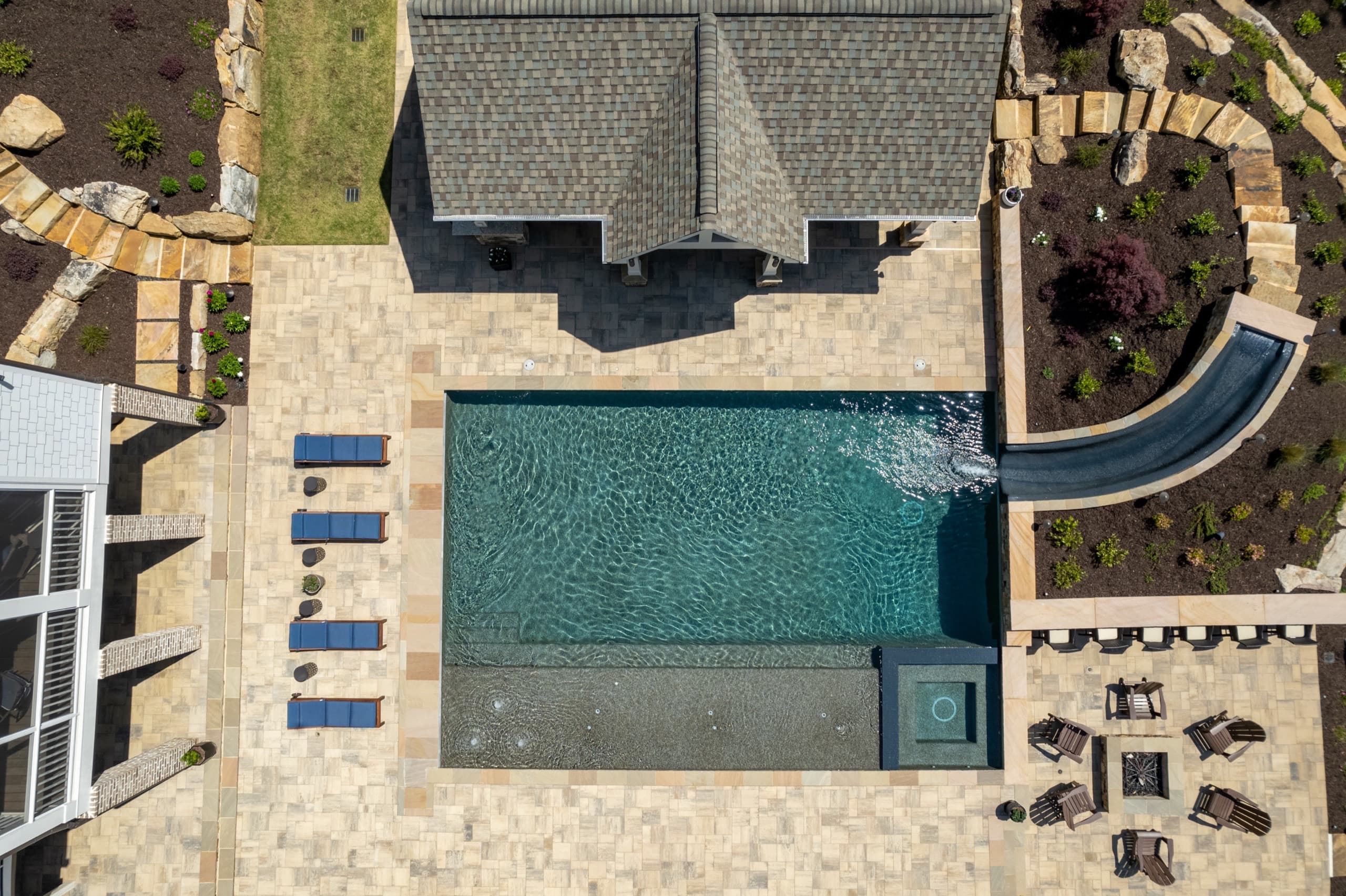 Aerial view of the Batchelor backyard in Roswell with its oversized pool, pavilion, fireplace, outdoor kitchen, and fire pit