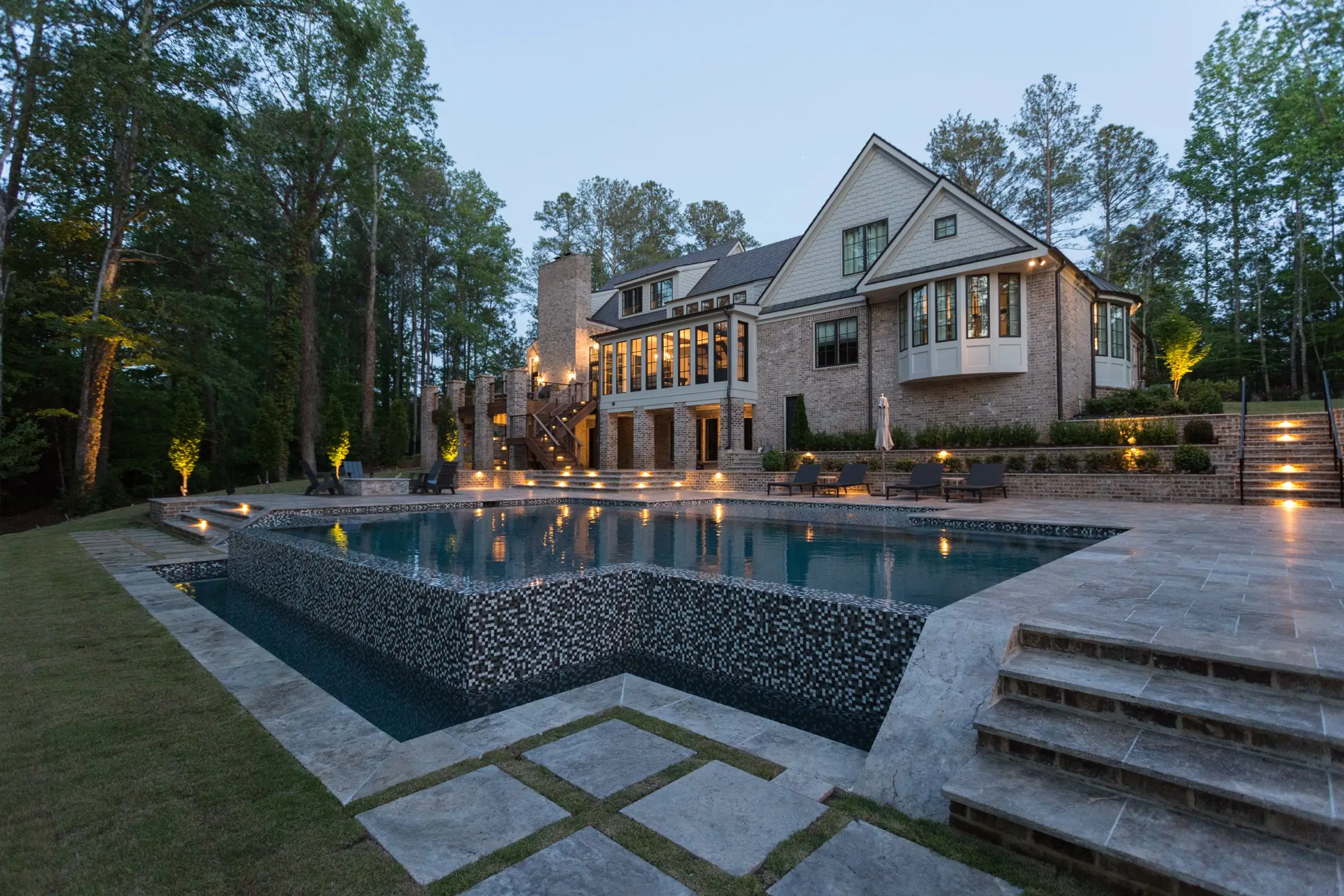 Steps into the Chadwell pool in Roswell at dusk, the vanishing edge and pool house beyond