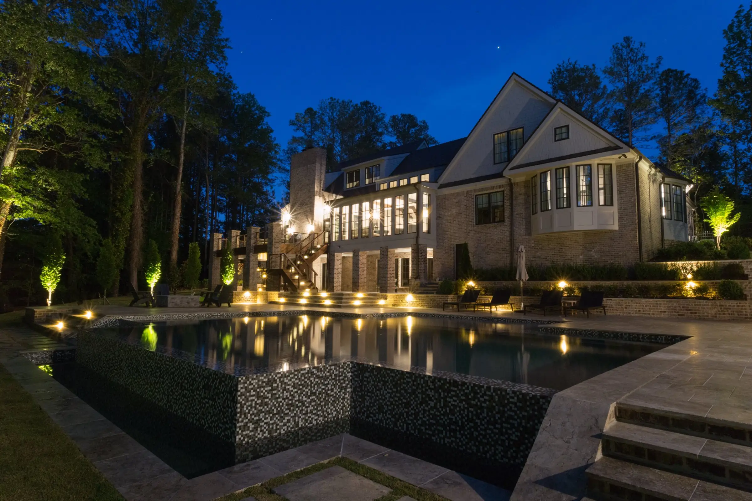 The Chadwell pool at night, its vanishing edge holding a precise line against the property beyond