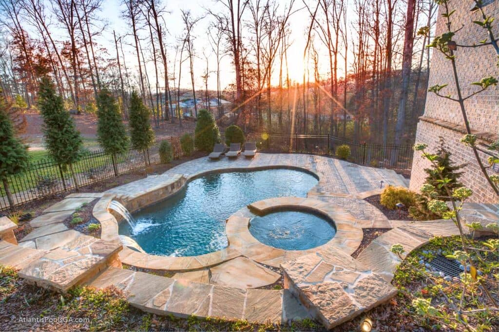 Stone decking laid at a pool edge, the kind of hardscape work a build finishes with