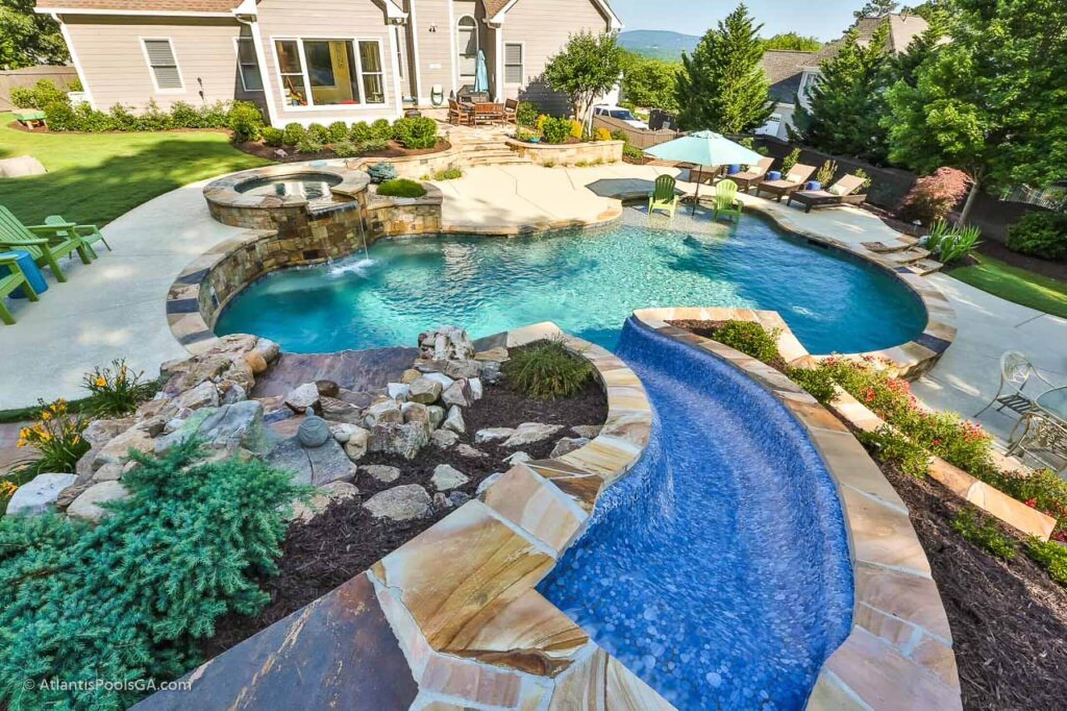 A freeform pool with irregular natural-stone coping set among mature trees
