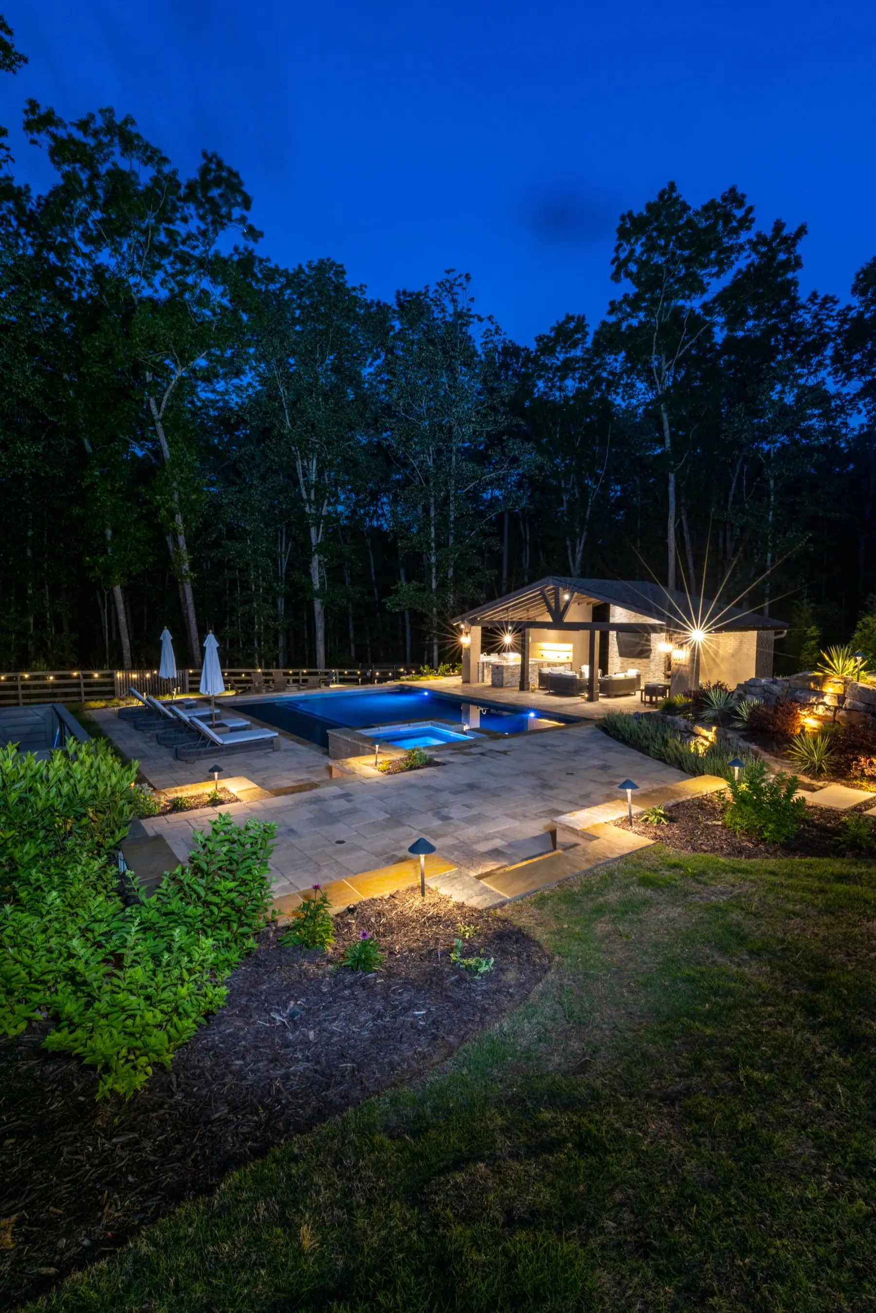 The Kahtri pool in Roswell at twilight, a portrait view of the water and pavilion lit against the evening sky