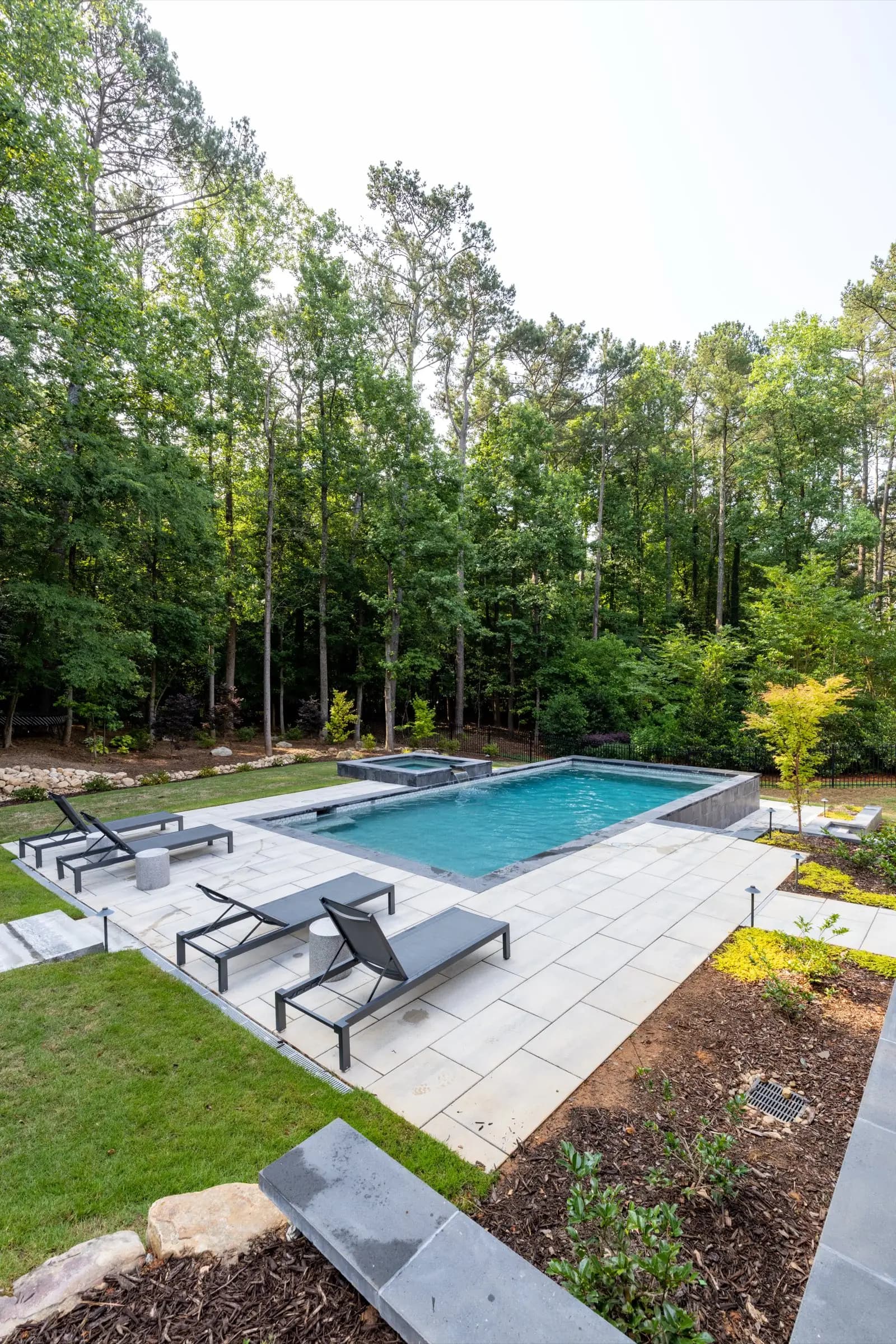 Aerial view of a linear pool holding a straight edge against the footprint of the house.