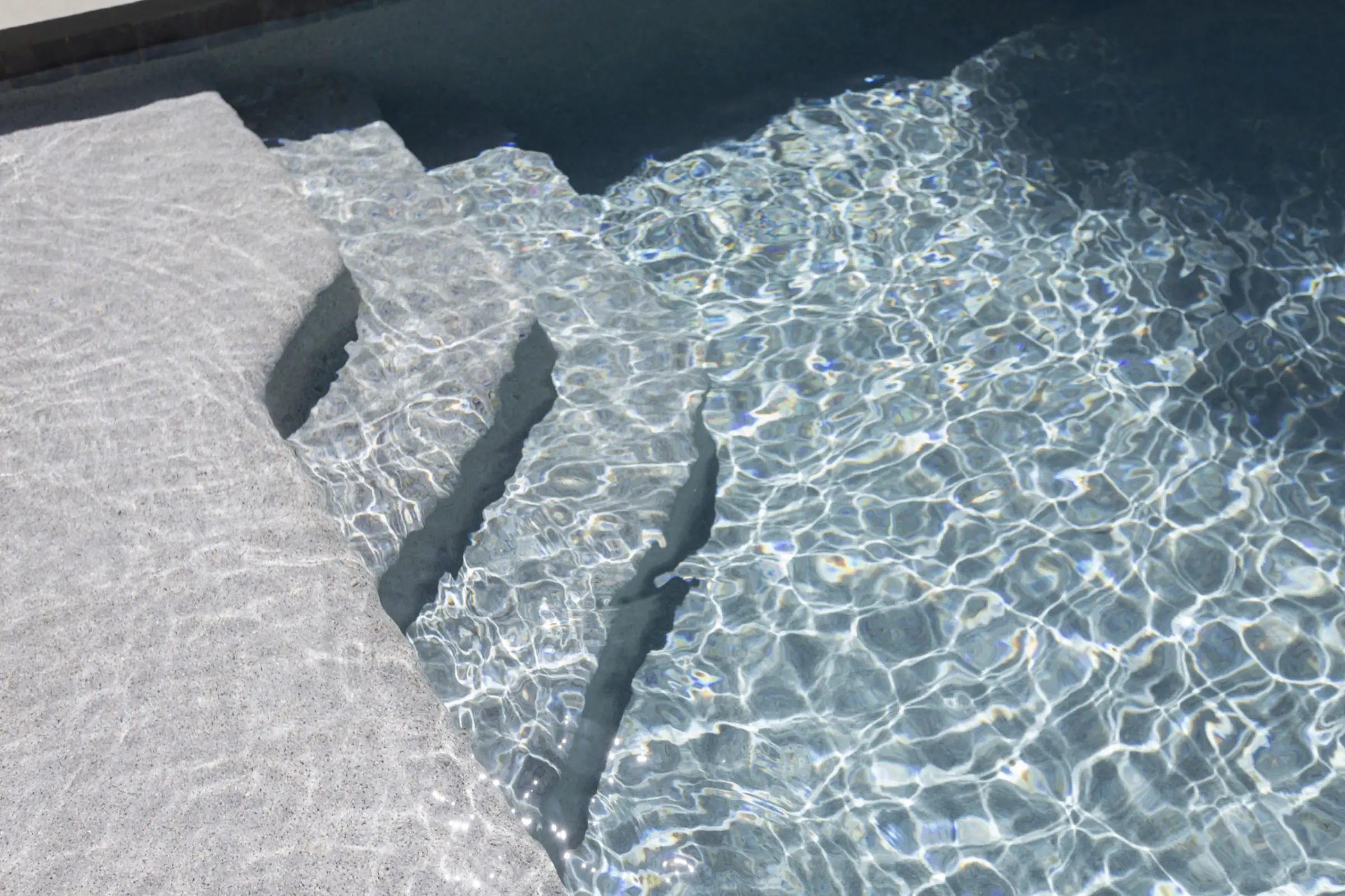 Wide entry steps cut into a linear pool, the same straight line carried the length of the pool's edge.