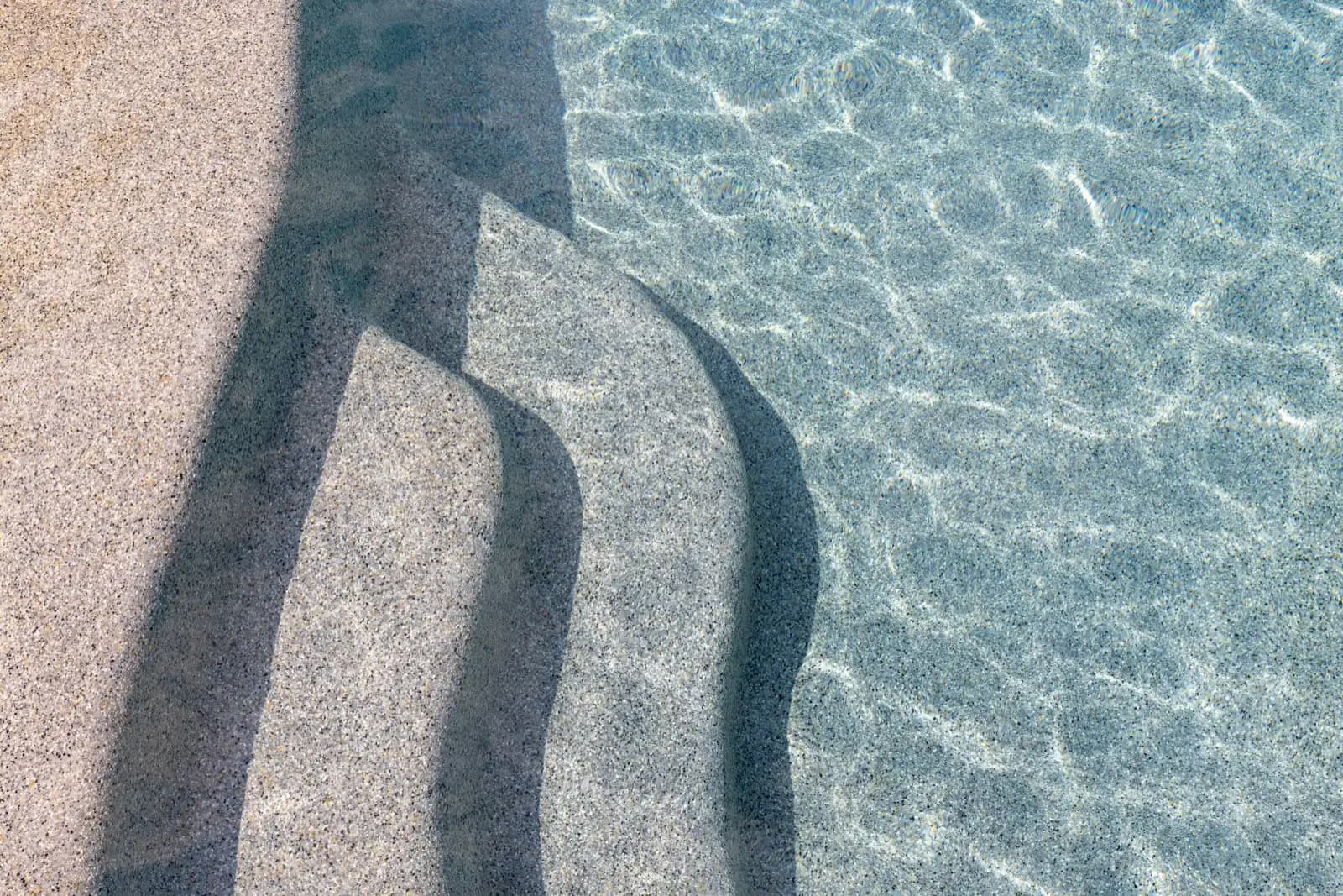 Close view of pool steps, waterline tile, coping, and the finish details a renovation can renew